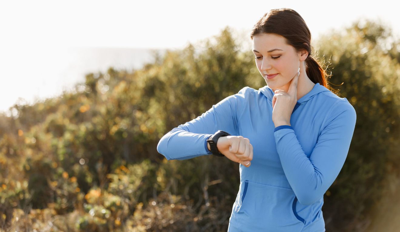 Mulher medindo a frequência cardíaca no treino de corrida